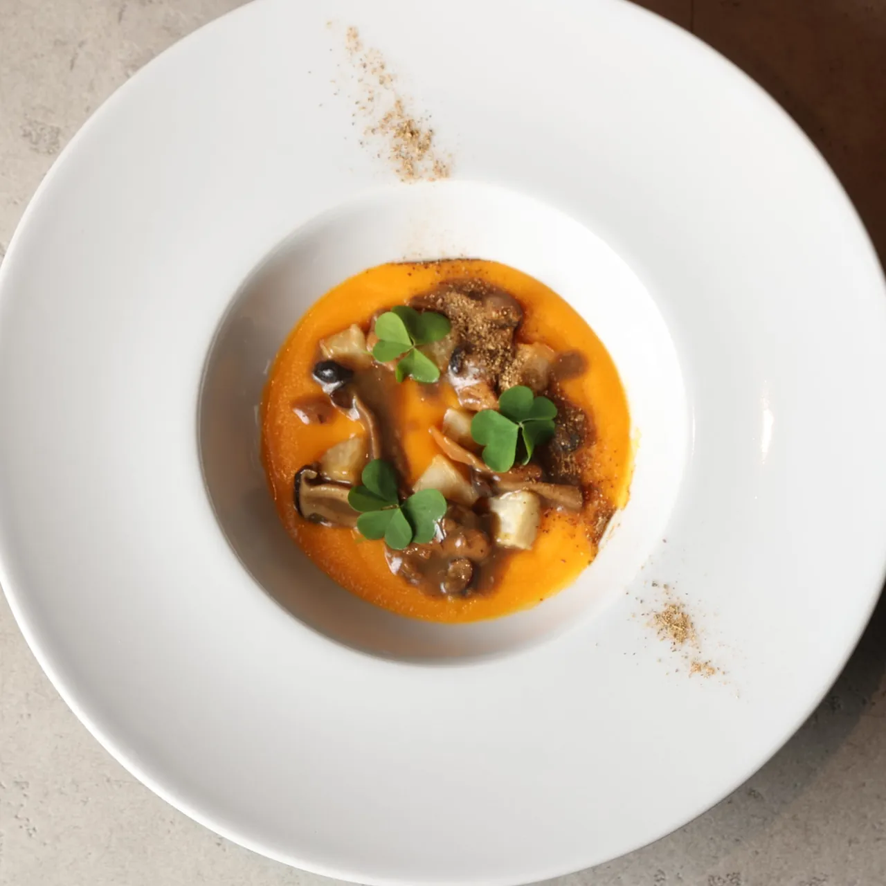 Potage arancio di patata dolce con ragù di funghi e germogli, polvere sul bordo del piatto, di Giuliano Fusaro