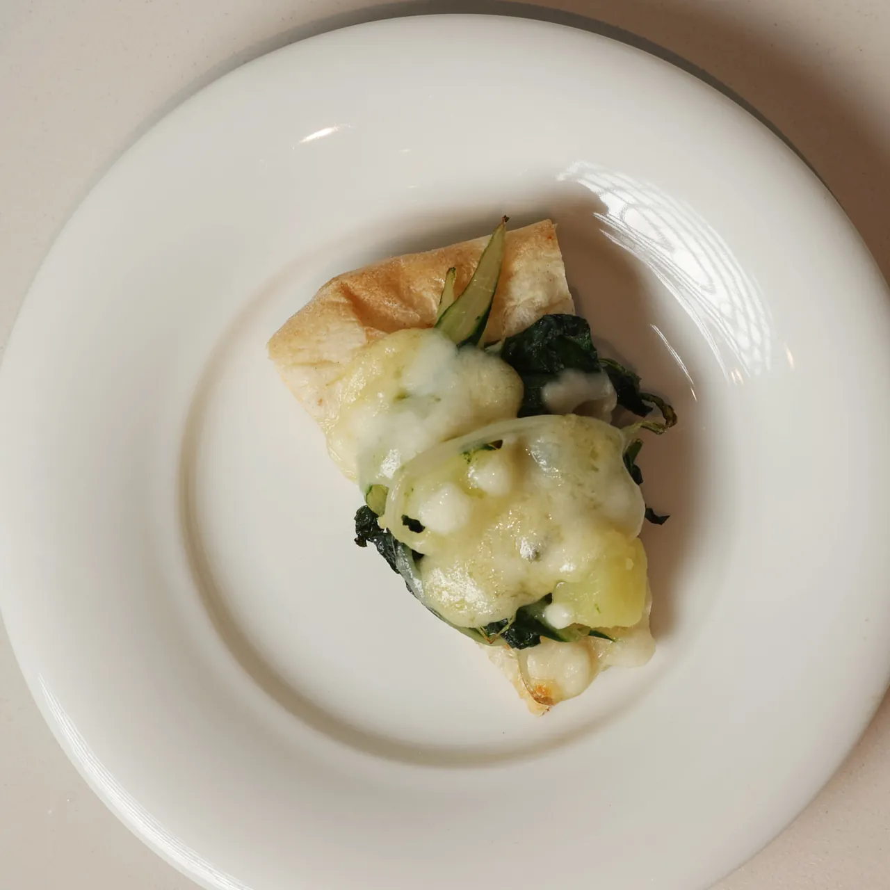 La pizzocchera di Corrado Scaglione, con verdure, patate e formaggio fuso, in un piatto bianco visto dall'alto